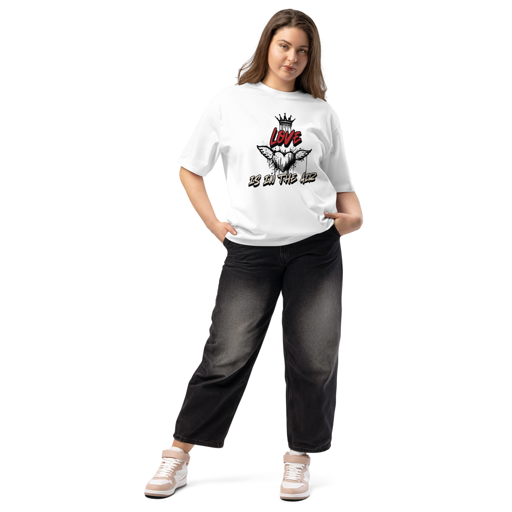 White oversized t-shirt with bold graffiti-style artwork featuring "Love is in the Air" tagging. A raw, urban design celebrating loyalty, love, and commitment.