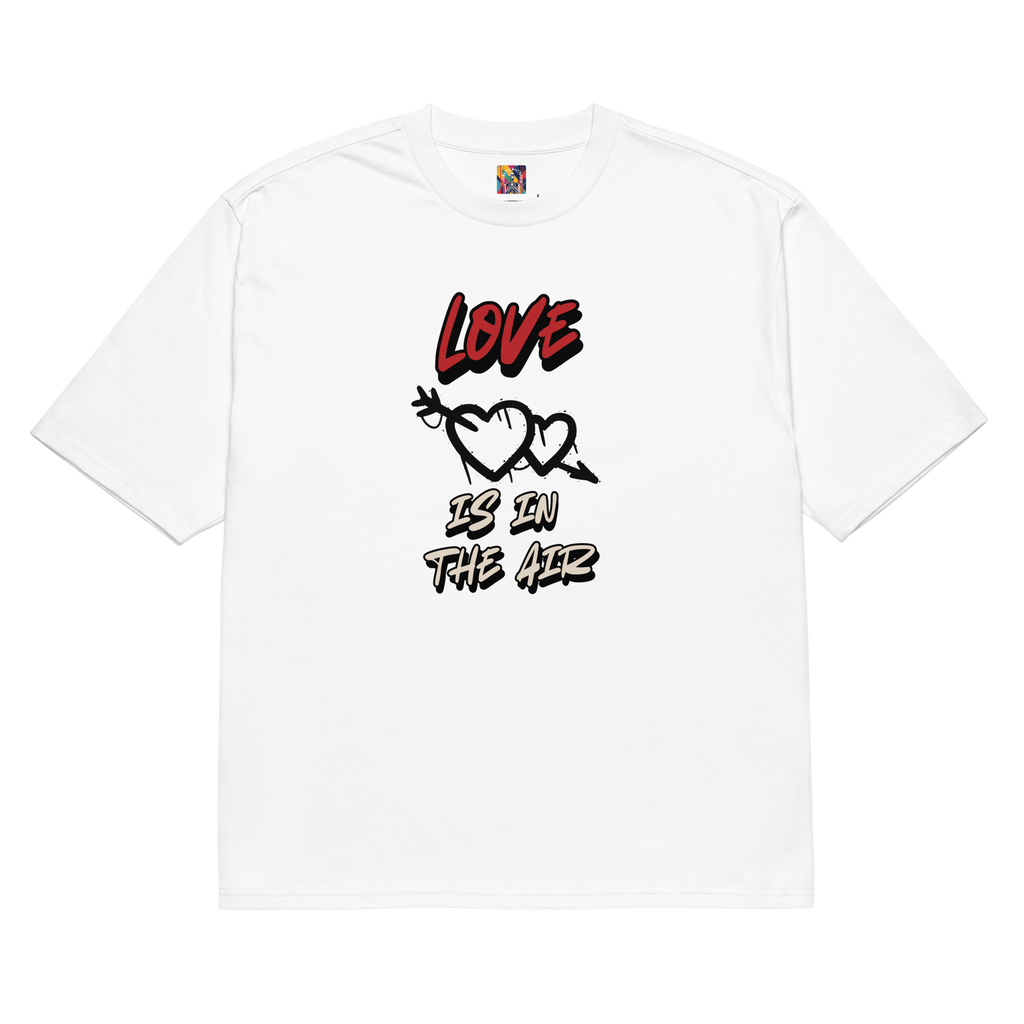 A white oversized tee with graffiti-tag lettering on the back and "Love is in the Air" artwork on the front. Streetwear-inspired, bold, and built to last.